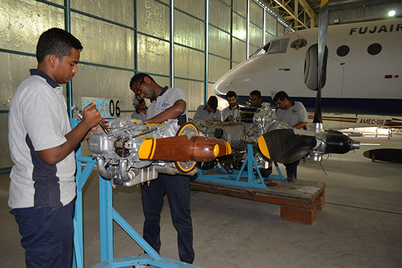 Students working on an aircraft in the training hangar